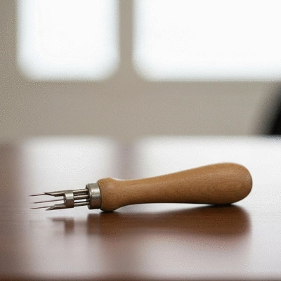 Close-up of a punch needle tool, colorful yarn, and fabric on a crafting table